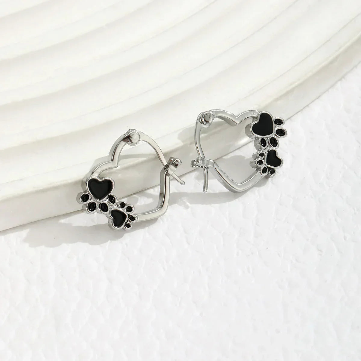 Huggie earrings with heart and black enamel.